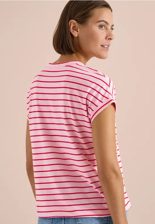 Une femme vue de dos porte un t-shirt à rayures blanches et roses.