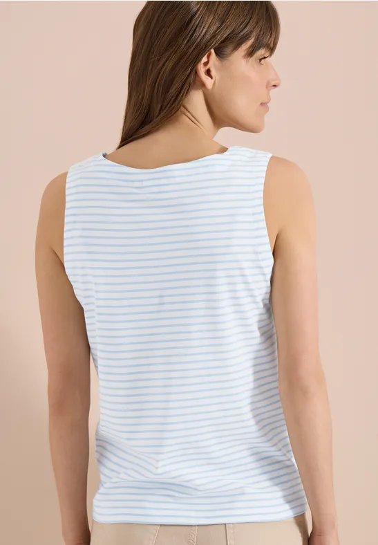 Une femme vue de dos porte un débardeur rayé blanc et bleu clair.