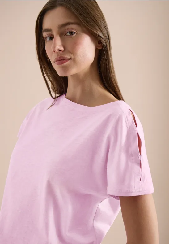 Haut rose pâle pour femme avec découpes aux manches, sur fond neutre.