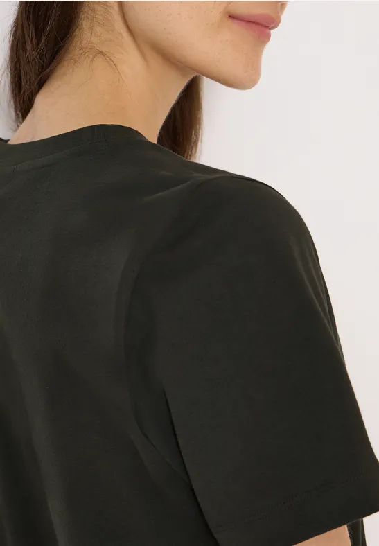 Teilansicht einer Person im dunklen T-Shirt, Rücken und Kinn im Profil zu sehen.