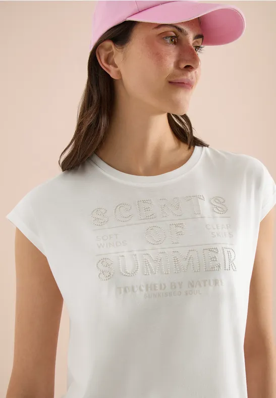 Frau trägt weißes T-Shirt mit 'Scents of Summer'-Aufdruck und rosa Cap