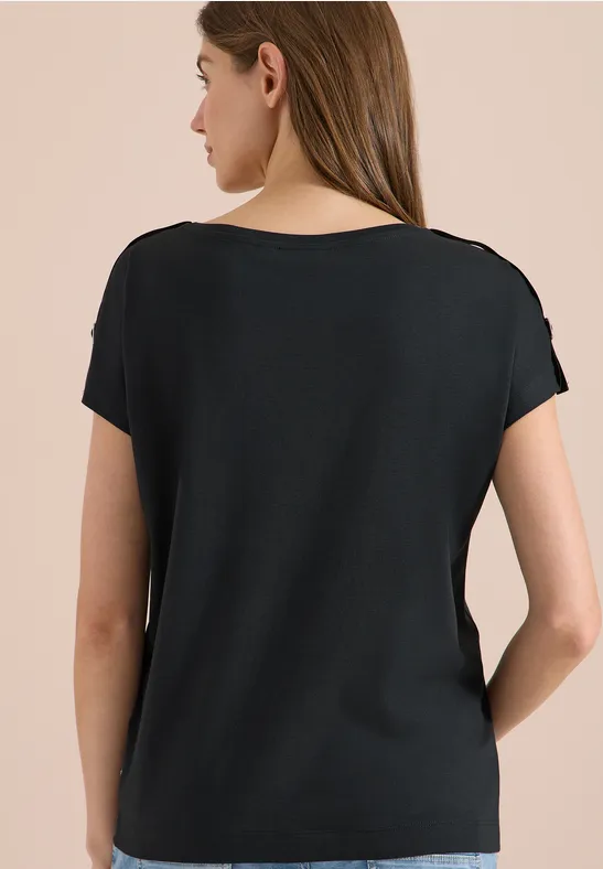 Vue de dos d'une femme portant un t-shirt noir simple sur fond neutre.