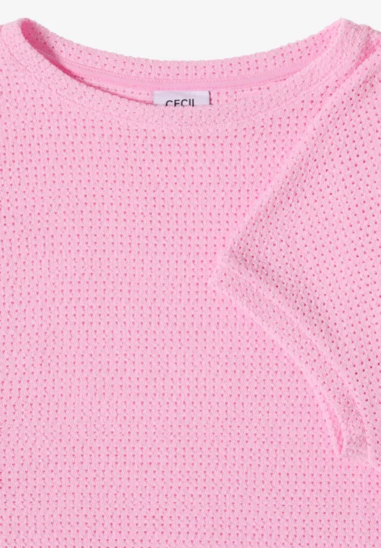 T-shirt plié rose pâle à manches courtes en maille aérienne.