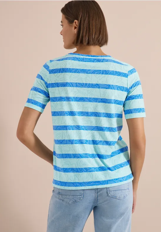 Eine Person von hinten in blau-gestreiftem T-Shirt und Jeans.
