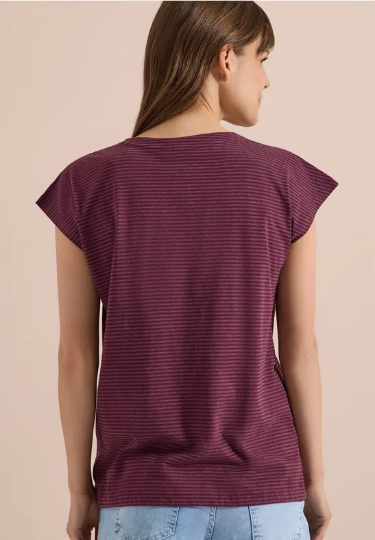 Vue de dos d'une femme portant un T-shirt violet à fines rayures, manches courtes et encolure arrondie.