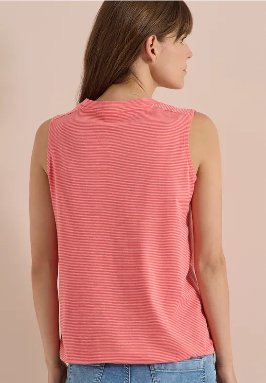 Rückenansicht einer Frau in ärmellosem, korallfarbenem Shirt.