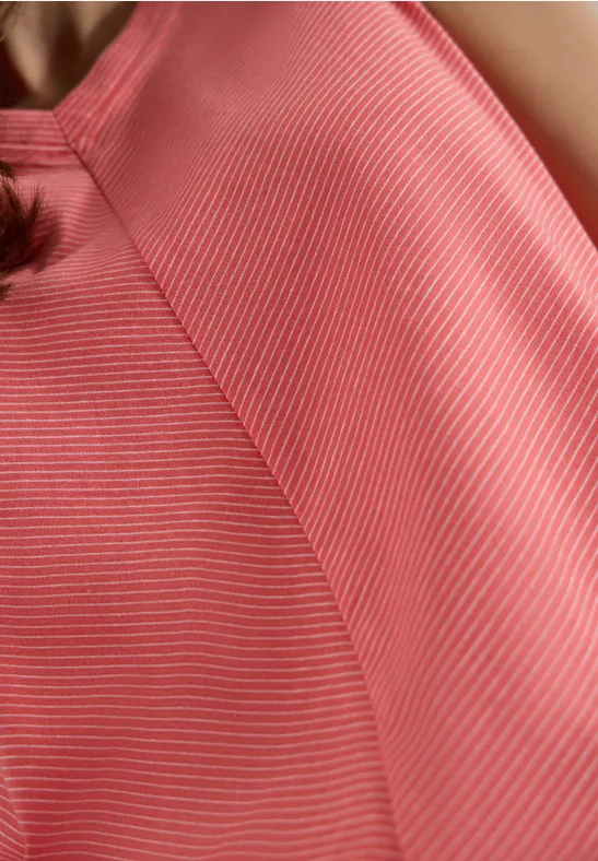 Nahaufnahme eines rosa-weiß gestreiften Tops auf Schulter und Oberkörper einer Person.