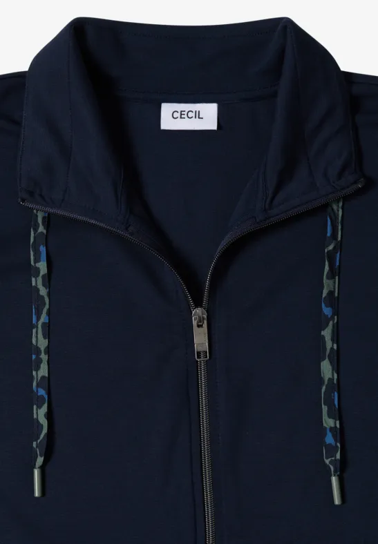 Dunkelblaue, leicht taillierte Zip-Jacke mit Camouflage-Kordeln und Stehkragen, Label "CECIL" innen im Kragen.