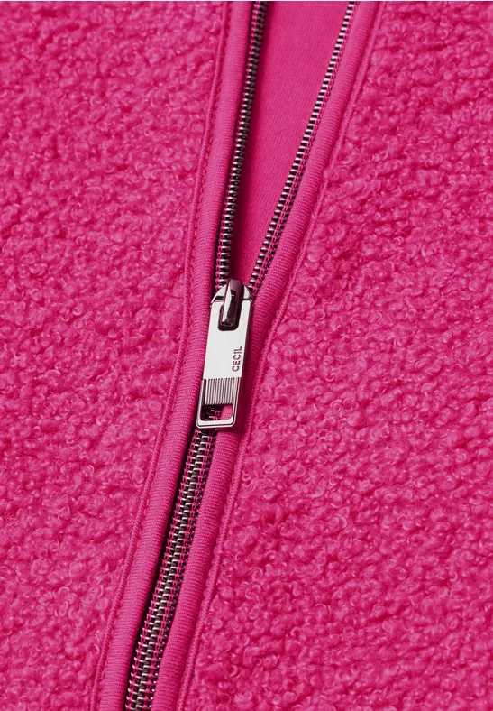 Leuchtend pinke Fleecejacke mit sichtbarem Reißverschluss und weichem, flauschigem Material.