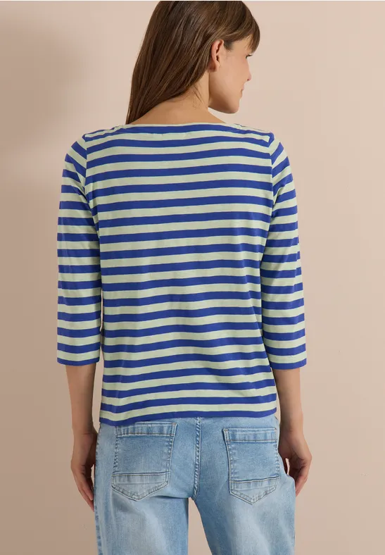 Femme vue de dos portant un t-shirt à rayures bleu et blanc à manches 3/4 et un jean bleu.