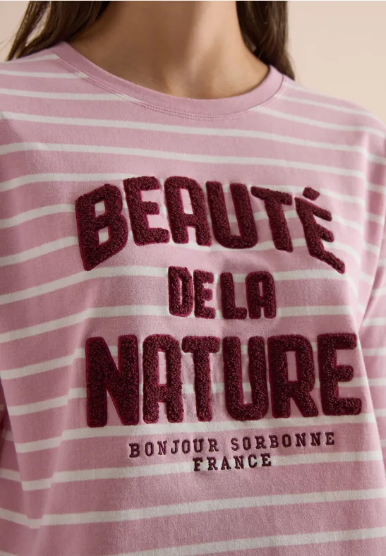 Porte un t-shirt rose à rayures blanches avec l'inscription « Beauté de la Nature » et « Bonjour Sorbonne France ».