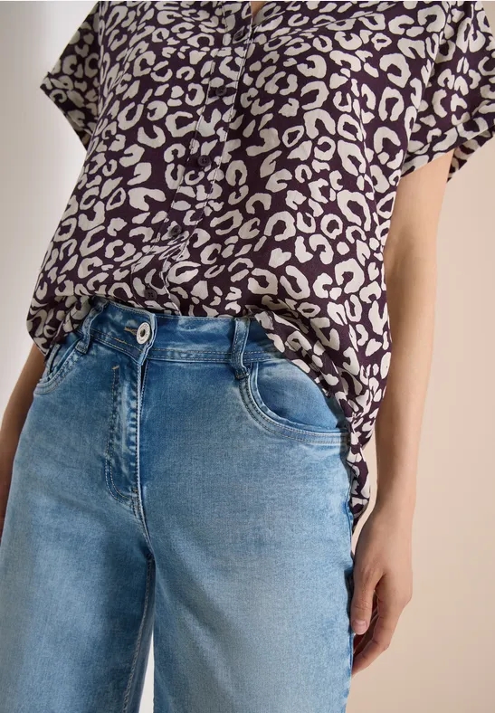 Leopardenmuster-Shirt und blaue Jeans in Oberkörperansicht.
