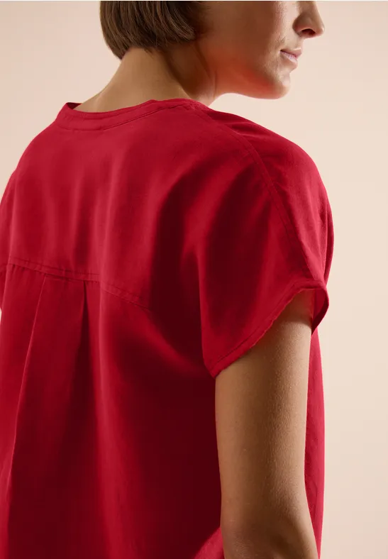 Frau in rotem T-Shirt von der Seite, Kurzarm, schlichte Passform.