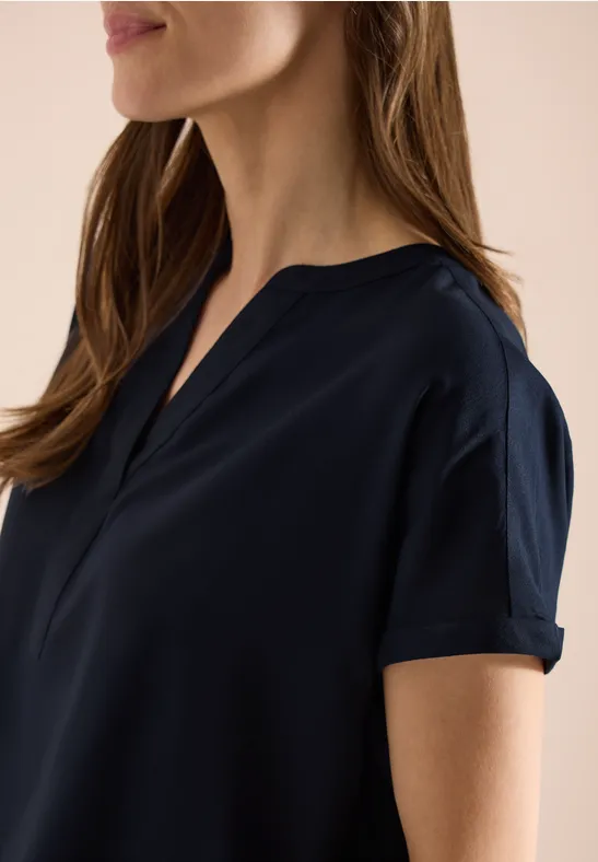 Dunkelblaue Damenbluse mit kurzen Ärmeln und kleinem V-Ausschnitt, schlicht und elegant.