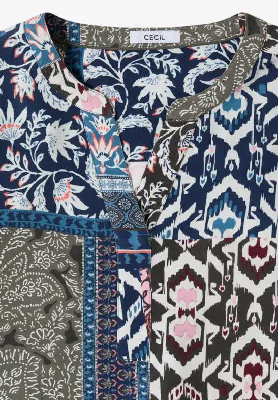 Bunte Patchwork-Bluse mit floralen und geometrischen Mustern in Blau, Weiß und Olivgrün.