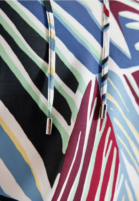 Vêtement rayé multicolore avec cordon, tons bleu, noir, blanc et bordeaux.