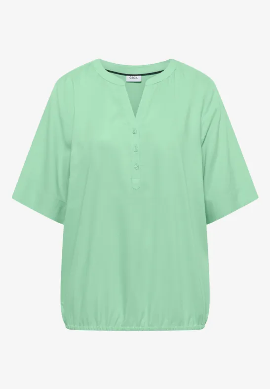 Haut féminin vert léger à manches courtes, encolure en V, patte de boutonnage et ourlet élastique.