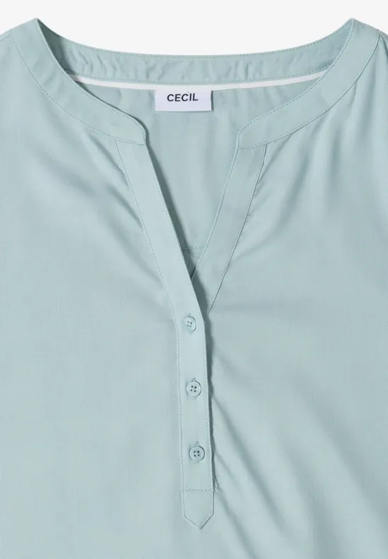 Haut femme vert pâle à encolure ronde avec patte de boutonnage courte.