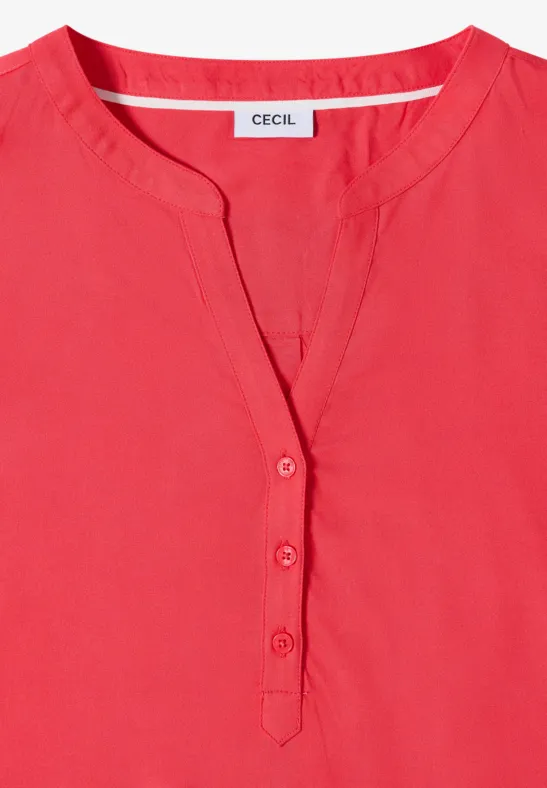 Blouse rouge pour femme avec encolure en V, patte de boutonnage et style épuré.
