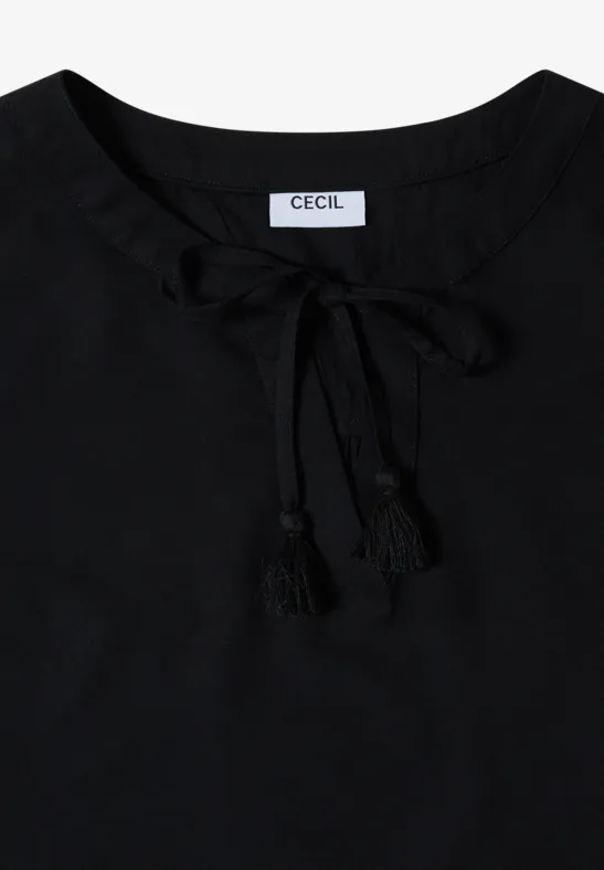 Haut noir pour femme avec col lacé et pompons décoratifs.