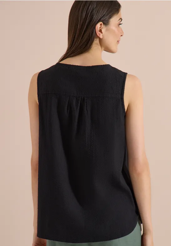 Vue de dos d'un débardeur noir sans manches pour femme, en tissu texturé, avec plis discrets sous la découpe yoke.