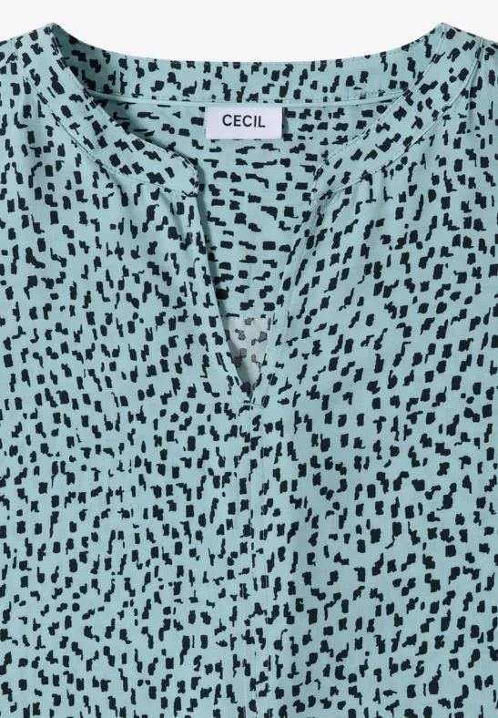 Haut féminin turquoise à col en V, motif taches noires, marque 'CECIL'.