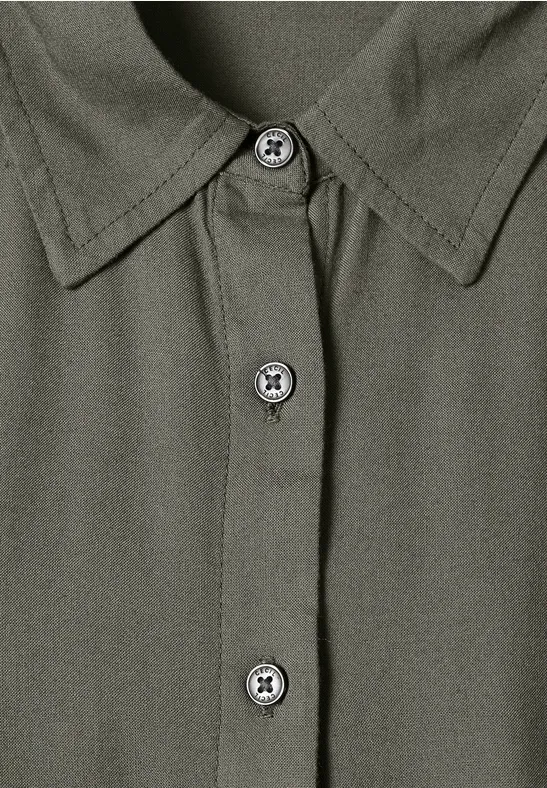 Vue rapprochée d'une chemise kaki à col et patte de boutonnage