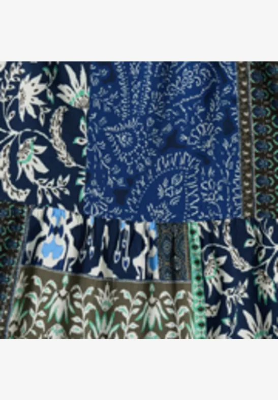 Patchwork-Muster aus blauem Stoff mit Paisley, Blumenranken und zarten grünen Blättern.