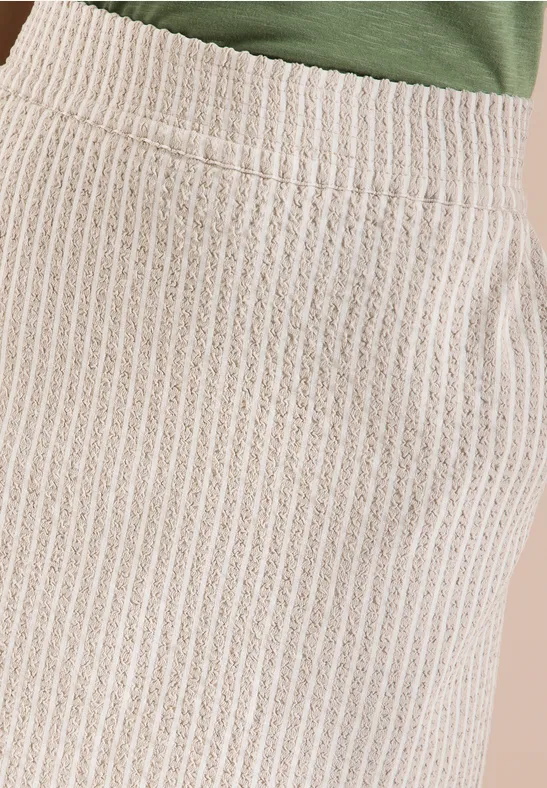 Gros plan d'une jupe beige en tricot côtelé avec poche.