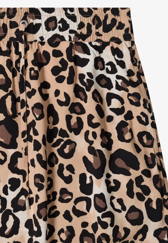 Jupe plissée beige à motif taches de léopard marron et noir.