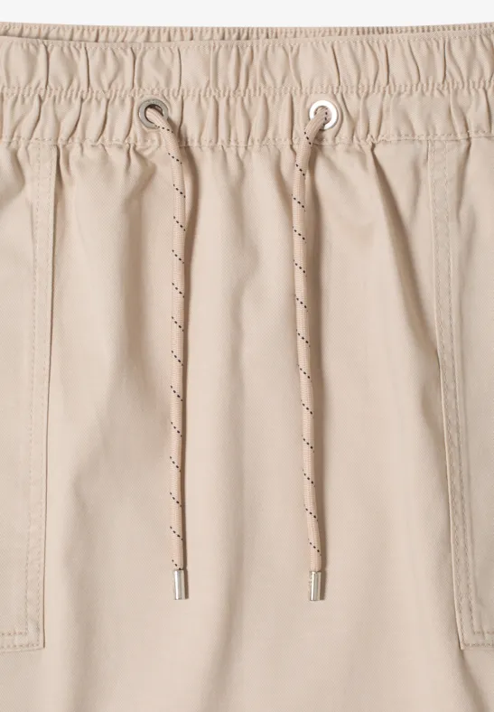 Short beige à taille élastique avec cordon.