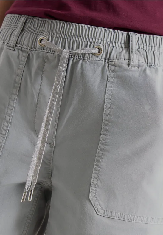 Nahaufnahme einer hellgrauen, elastischen Bundhose mit Eingriffstaschen und kontrastfarbigem Tunnelzug.