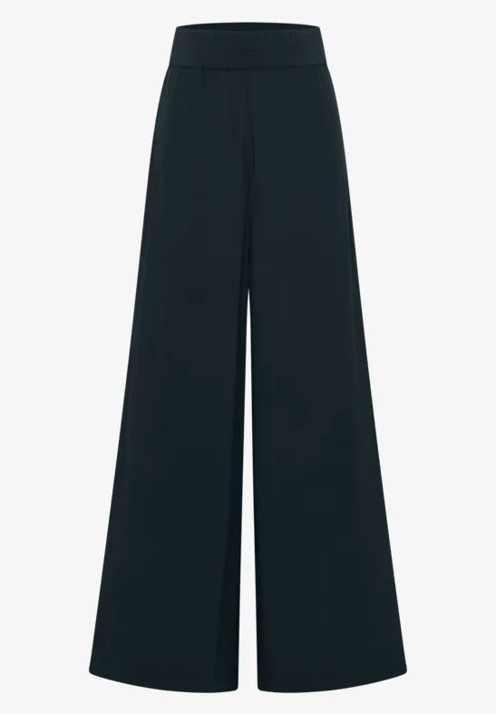 Pantalon noir ample taille haute avec jambes évasées.