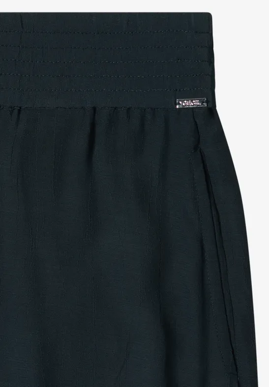 Une jupe noire taille haute avec une large ceinture et des plis discrets.