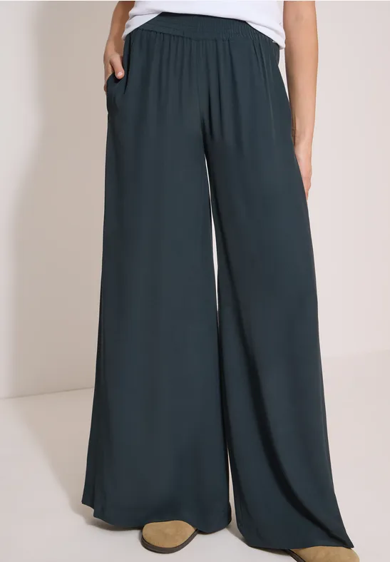 Pantalon large noir pour femme avec ceinture élastique et poches.