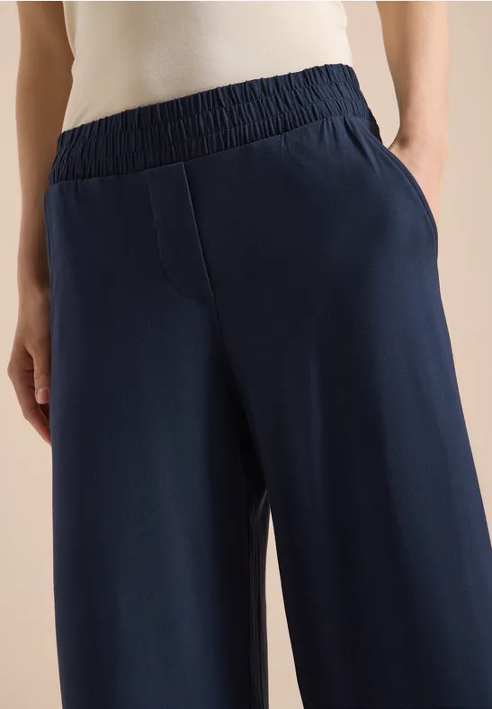 Blaue Jerseyhose für Damen mit weitem Bein, elastischem Bund und seitlichen Taschen.