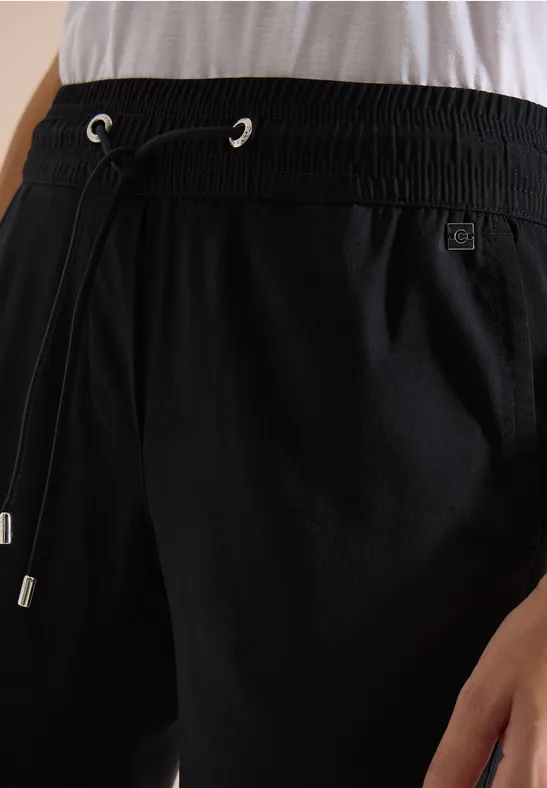 Nahaufnahme einer schwarzen Hose mit elastischem Bund und Kordelzug.
