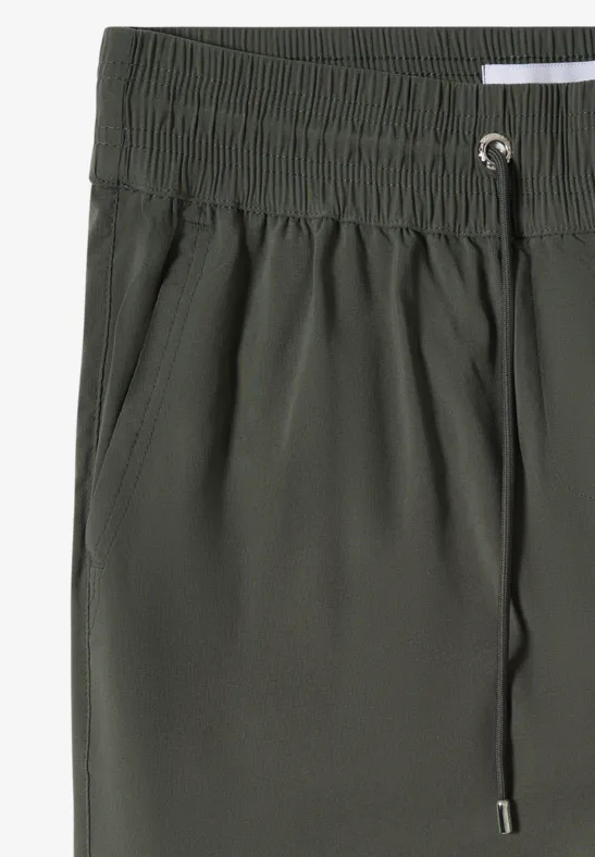 Short vert à taille élastique avec cordon de serrage et poches latérales.