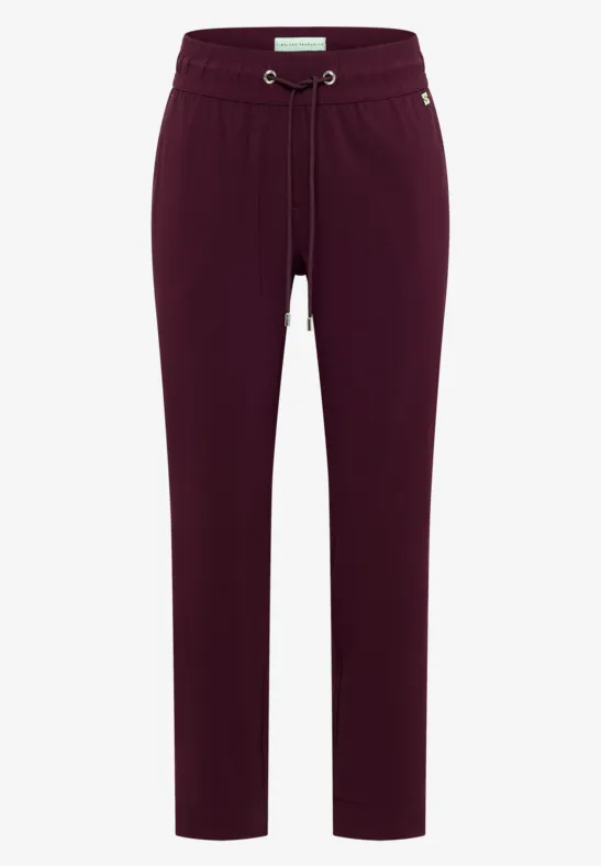 Bordeauxrote, sportliche Hose mit Tunnelzug und Seitentaschen, schmal zulaufend.
