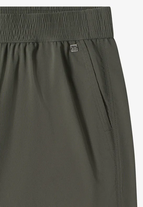 Detailansicht einer olivgrünen Sporthose mit elastischem Bund und seitlicher Eingrifftasche.