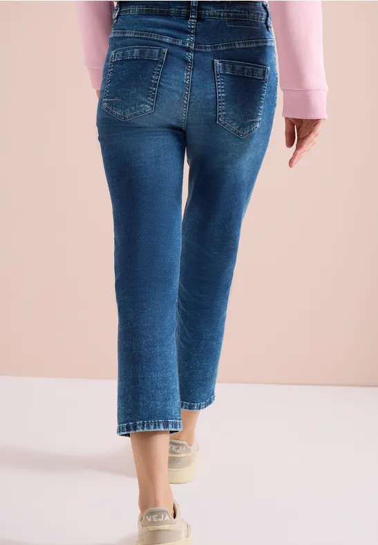 Rückansicht einer Person in hochgeschnittenen, knöchellangen blauen Jeans.