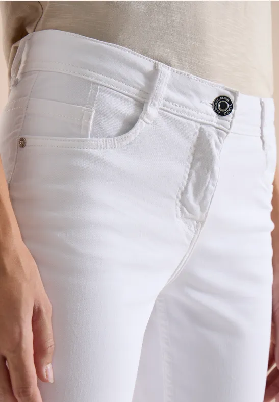 Seitliche Aufnahme einer Person in hellem Oberteil und weißen Jeans, Fokus auf Hüfte und Hand