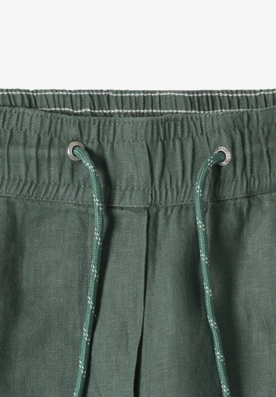 Pantalon en lin vert avec ceinture élastique et cordon de serrage.