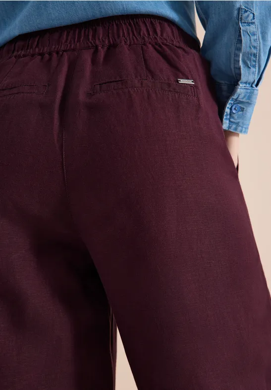 Rückansicht dunkelroter Hose mit elastischem Bund und Gesäßtasche