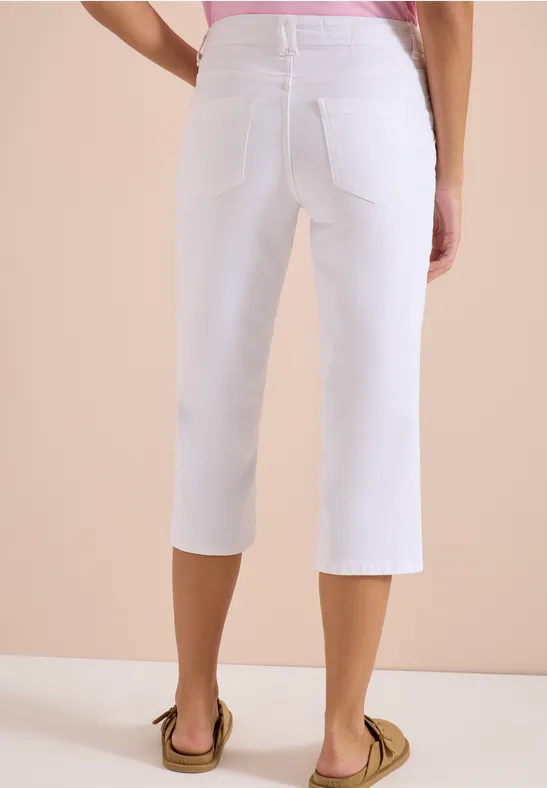 Frau von hinten in weißer Caprihose und Sandalen