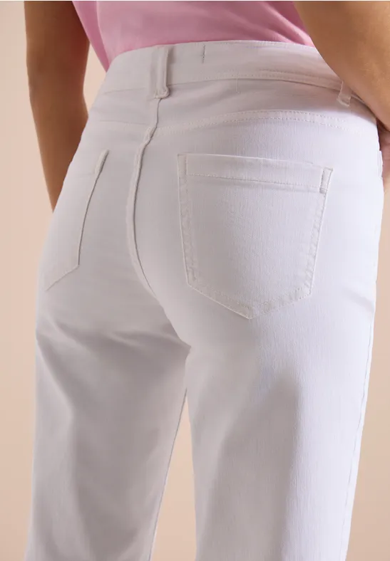 Nahaufnahme eines Gesäßes in weißen Jeans und rosa Oberteil.