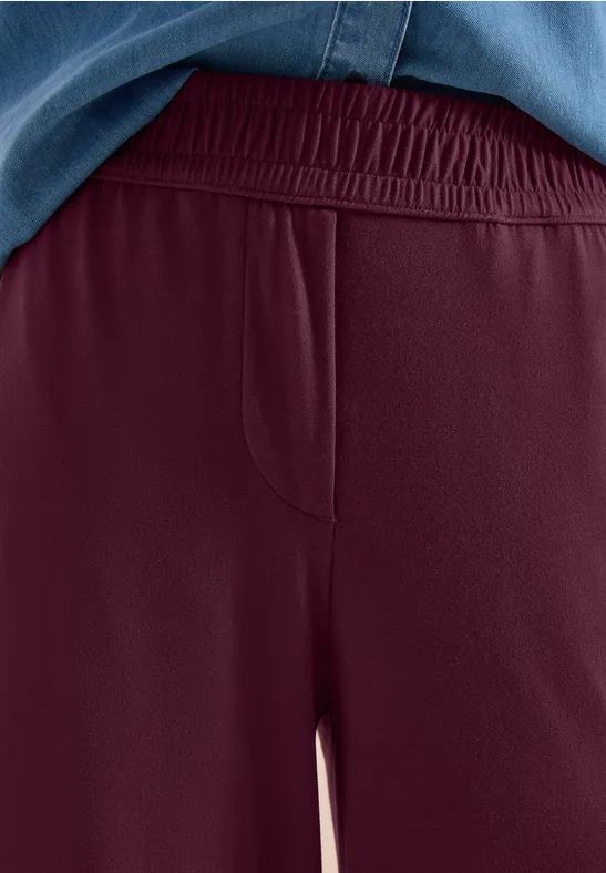 Burgunderrote, lässige Jersey-Hose mit elastischem Bund und seitlicher Tasche.