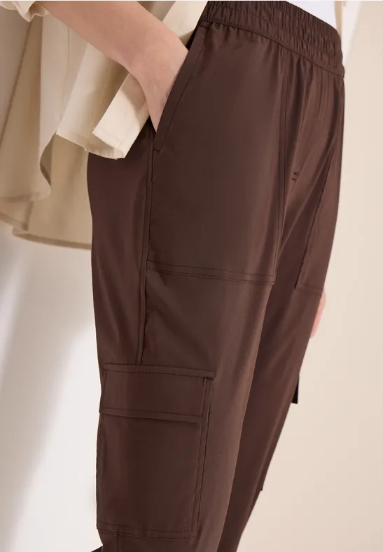 Braune Cargo-Hose mit elastischem Bund und aufgesetzten Taschen an den Beinen.