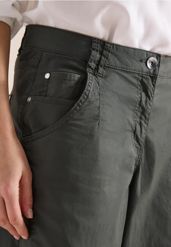 Damenhose in Olivgrün mit fünf Taschen, dazu helles Oberteil