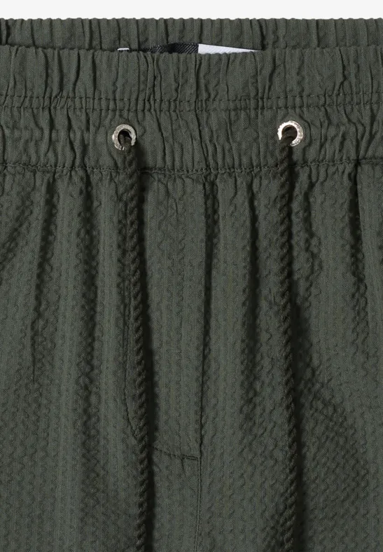 Dunkelgrüne, strukturierte Shorts mit elastischem Bund, Kordelzug und Waffelstruktur-Optik.